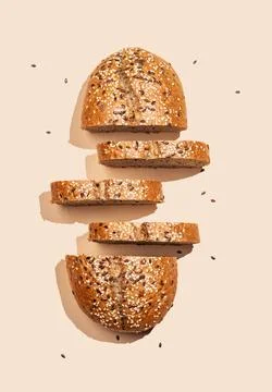 Freshly sliced multigrain bread with sesame and flax seeds on a bright beig.. Stock Photos