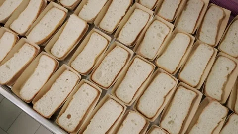 Freshly sliced white bread loaves arranged neatly in trays, showcasing a Stock Footage 340172370