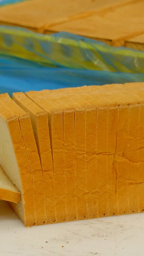 Freshly sliced white sandwich bread upright stack in bakery on clean tabletop Vidéo 344573597