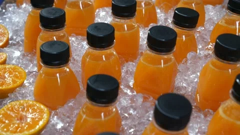 Freshly Squeezed Orange Juice in Plastic Bottle Standing in Ice on Street Market Stock Footage 130230734