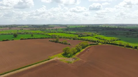 Freshly tilled arable fields with tractor working spring soil preparation Stock Footage 340325983