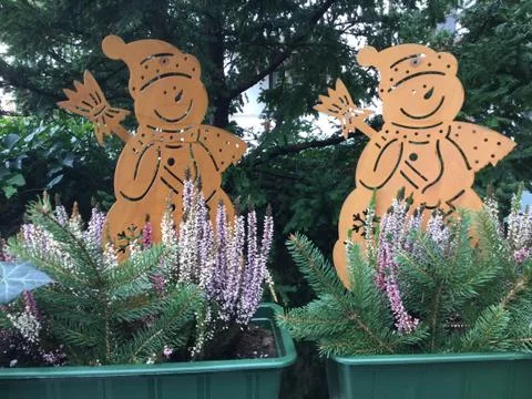 Fretwork of two snowmen sitting in window boxes together with heather Stockfoto's