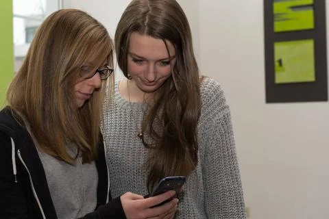 Freundinnen mit Handy Teenager zeigt anderem Maedchen am Handy Interessant... Stock Photos