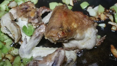 Fried appetizing wings with a crust with onions and vegetable peppers, macro Vídeos de archivo 225243053