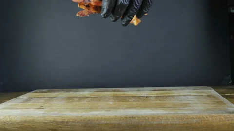 Fried bacon, one slice tosses on a wooden board, flying bacon, black isolated Video stock 105465806