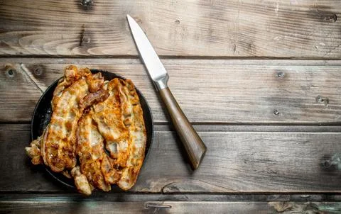 Fried bacon in a pan. Stock Photos