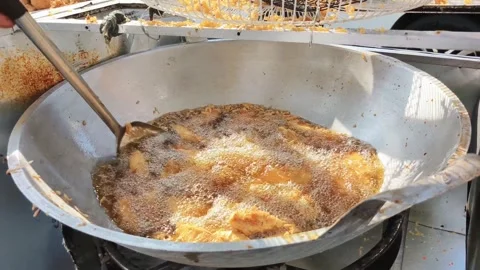 Fried bananas are being stirred in a frying pan to ensure they are evenly c.. Stock Footage 330447682