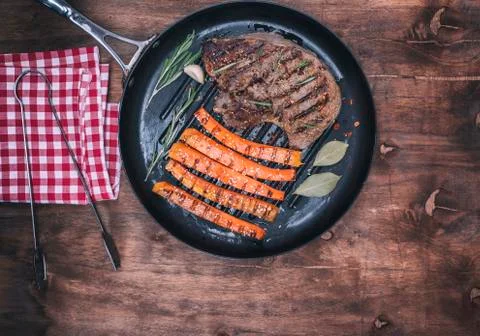 Fried beef stack and fried carrots on a round frying pan Foto stock