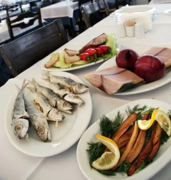 Fried bonito fish, dried cod and pickled tunny on the restaurant table. Stock Photos