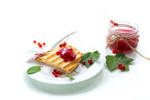 Fried bread croutons for breakfast with redcurrant jam in a plate with berrie Stock Photos