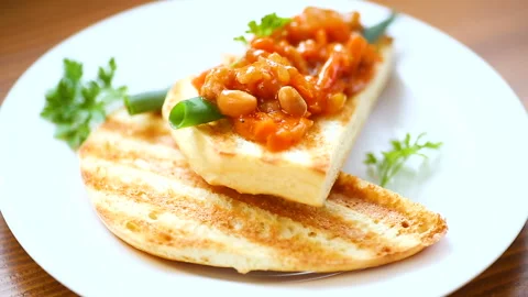 Fried bread toasts with stewed beans and vegetables in a plate Stock Footage 104098877