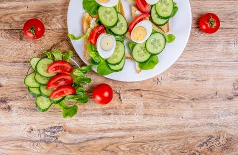 Fried bread toasts with vegetable and egg slices and salad Stock Photos
