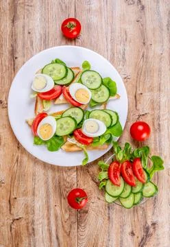 Fried bread toasts with vegetable and egg slices and salad Foto stock