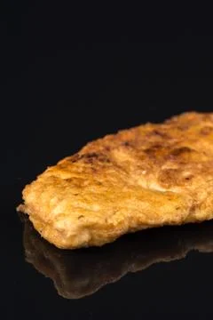 Fried breaded chicken white meat breasts in eggs above black background table Stock Photos