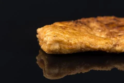 Fried breaded chicken white meat breasts in eggs above black background table Foto stock