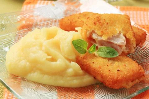 Fried breaded fish fillets served with mashed potato Stock Photos