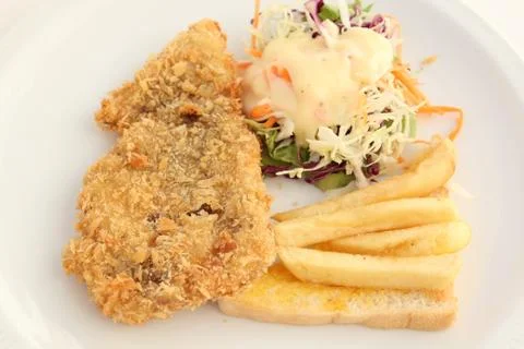 Fried breaded fish steak with salad and french-fried Stock Photos
