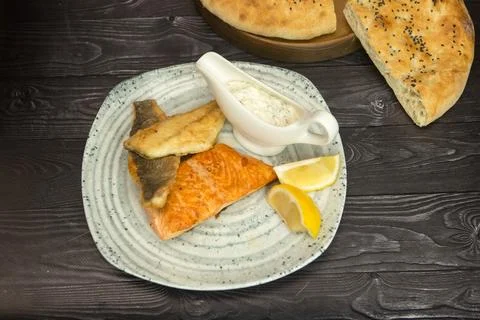 Fried breaded fish with white sauce and lemon Stock Photos