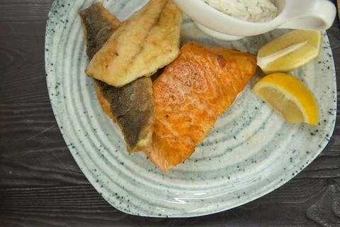 Fried breaded fish with white sauce and lemon Stock Photos
