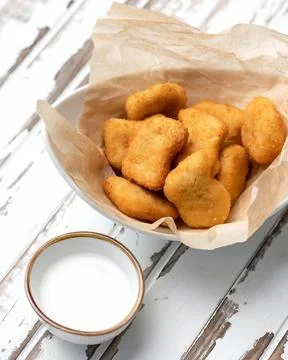 Fried breaded pieces of cheese or meat in parchment paper with milk sauce. Light Stock Photos