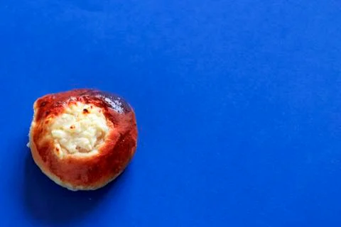 Fried bun on blue background close up Stock Photos