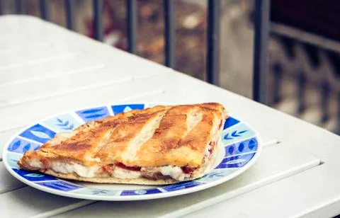 Fried calzone pizza with ham, mozzarella, tomatoes from bakery shop of Catani Stock Photos