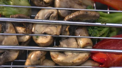 Fried chamignons and vegetables on grill grate. Slow motion Stock Footage 219496256