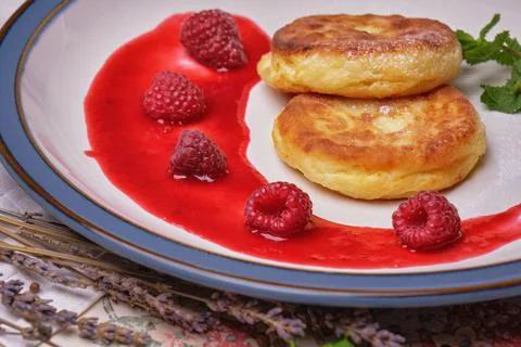 Fried cheese cakes pancake with raspberry jam and mint Stock Photos