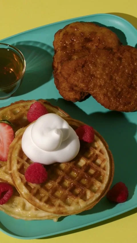 Fried chicken and waffles served on teal blue plate Video stock 331781067