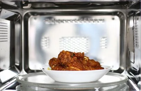Fried chicken dish inside of microwave oven Stock Photos