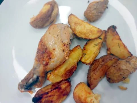 Fried Chicken Drumstick Served With Crispy Baked Potato Wedges on a White Pla Stock Photos