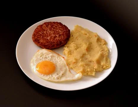 Fried chicken egg, mashed potatoes and juicy beefsteak in a round plate on .. Foto stock