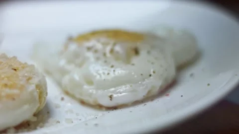 Fried chicken eggs, shape in the form of a heart. Seasoning fried egg with black Stock Footage 146667825