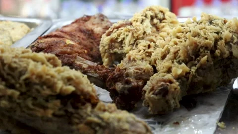 Fried chicken macro video capturing golden crust texture beside darker Stock Footage 338164690