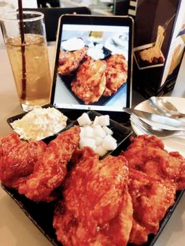 Fried chicken on plate in restaurant with drink and menu Stock Photos