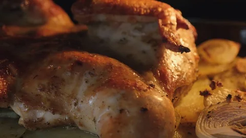 Fried chicken with spices and potatoes on a baking sheet is fried in the oven Stock Footage 128667783