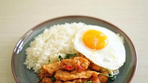 Fried chicken thigh with fried egg and rice on a plate Stock Photos