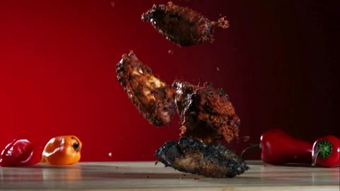 Fried chicken wings fall and bounce on a wooden surface Stock Footage 326626013