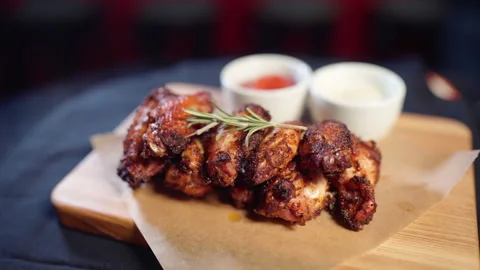 Fried chicken wings on a platter with different sauces Stock Footage 188684324