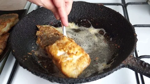 Fried cod battered in a cast iron skillet rustic Stock Footage 72754431