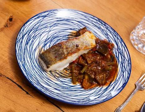 Fried cod fish garnished with vegetable ragout Stock Photos