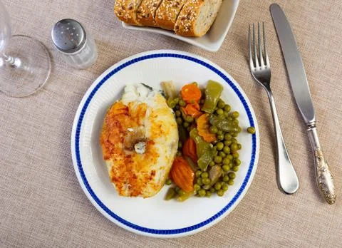 Fried cod fish garnished with vegetable ragout Stock Photos