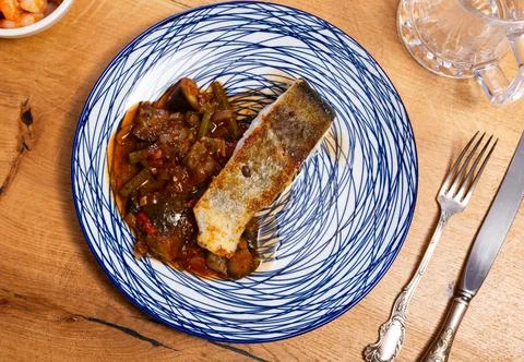 Fried cod fish garnished with vegetable ragout Stock Photos