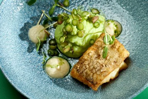 Fried cod with mashed peas and truffle oil. Bright backgrounds. Hard shadows, Stock Photos