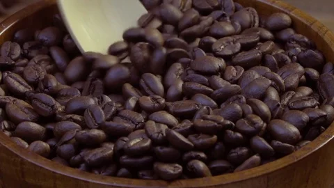 Fried coffee beans are collected in a wooden spoon from wooden utensils. Stock Footage 79050313