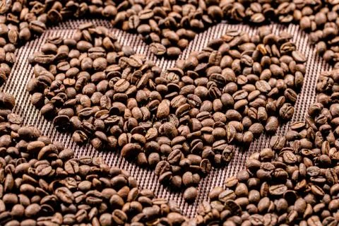 The fried coffee beans lie in the shape of a heart. Arab coffee. Morning coff Stock Photos