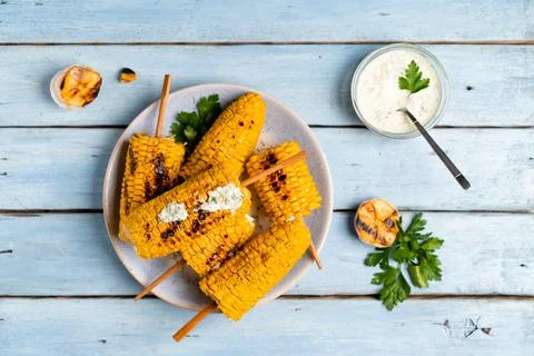 Fried corn on a light plate and a blue wooden table with sauce, top view Foto stock