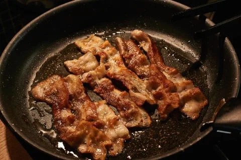 Fried crispy bacon in a close-up pan on top horizontally Stock Photos