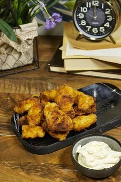 Fried Crispy Chicken Bites With Dipping Sauce on Wooden Table Near Clock and Boo Stock Photos