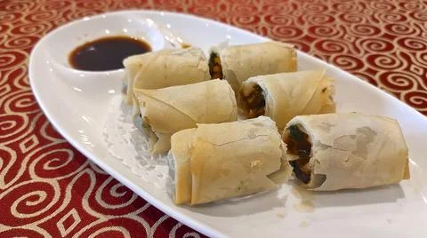 Fried crispy Chinese spring roll on white plate Stock Photos